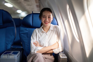 Successful asian businesswoman or female entrepreneur in a plane sits in a business class seat