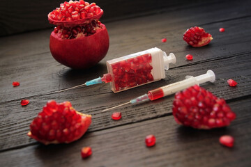 Concept, food as medicine. Pomegranate seeds in a rectangular syringe symbolize a healthy lifestyle, longevity. Pomegranate, as a king of fruits, contains many vitamins, antioxidants, minerals, iron,  - obrazy, fototapety, plakaty