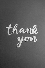 Thank You Paper Cutout on Dark Grey Background. Vertical. Copy space