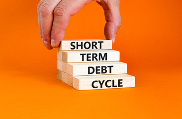 Short term debt cycle symbol. Concept words Short term debt cycle on beautiful wooden block. Beautiful orange table background. Businessman hand. Business Short term debt cycle concept. Copy space.