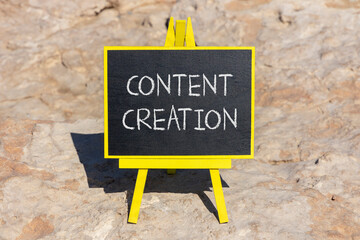 Fototapeta premium Time for content creation symbol. Concept words Content creation on beautiful black blackboard. Beautiful stone beach background. Business time for content creation concept. Copy space.