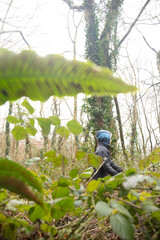 View of a Child walking in the woods with leaves in the foreground