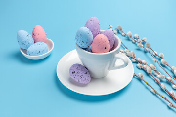 Cup with colored Easter eggs on the blue background.