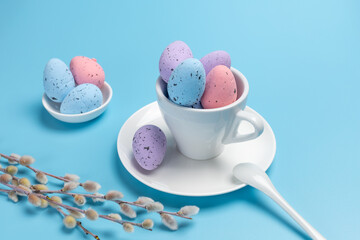 Cup with colored Easter eggs on the blue background.
