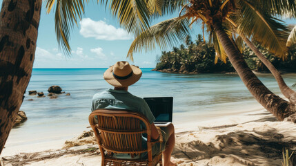 A person working remotely on a laptop under the shade of palm trees, with the serene blue ocean in the background. - obrazy, fototapety, plakaty