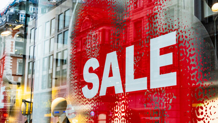 Large Sale sign in white and red in a retail shop window