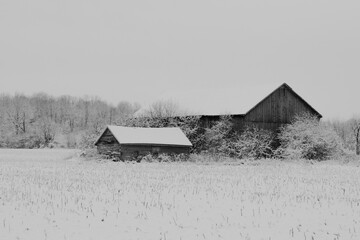 A barn sits covered in snow
