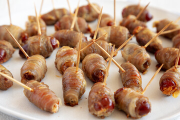 Homemade Bacon Wrapped Dates on a Plate, low angle view. Close-up.