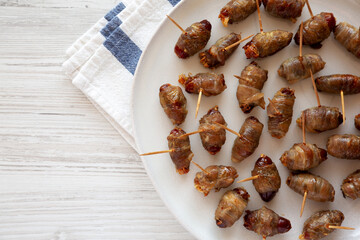 Homemade Bacon Wrapped Dates on a Plate, top view. Space for text.