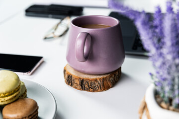 A sleek white desk adorned with a vibrant purple coffee mug, perfect for a cozy office setup or a...