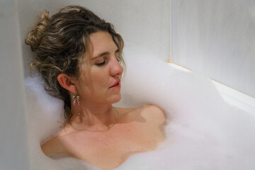 Attractive young woman relaxing in bathtub