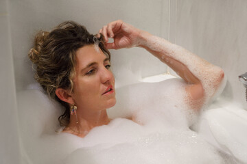 Attractive young woman relaxing in bathtub