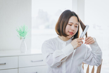 ヘアーアイロンする女性　
woman ironing hair