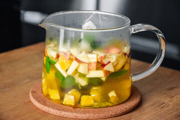 Glass hot teapot with sliced apple, orange, mint and cinnamon