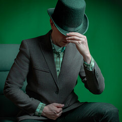 Stylish gentleman in a bowler hat sitting in a chair
