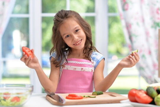 Portrait of cute little girl making dinner