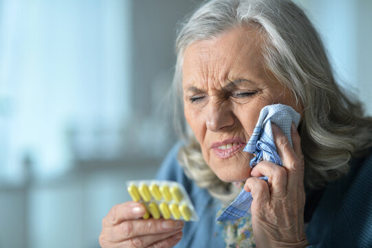 Portrait of sick elderly woman with headache