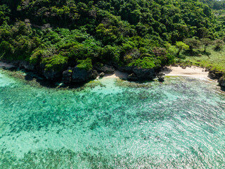 Sun reflection on clear turquoise water with corals in sandy beach in Boracay, Philippines.