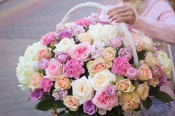 Girl florist holding a basket of flowers in her hands