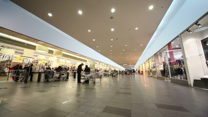 Clients with baskects at cash-desk in long supermarket
