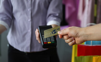 Close-up view of person making payment using credit card. Store seller holding terminal. Contactless method to pay bills. Modern technology and faster shopping concept