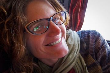 Portrait of a woman with glasses in a long distance bus