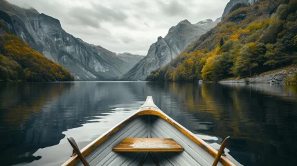 Foto op Canvas Enjoy in river under mountain, view from the bow of a small white wooden boat to the calm lake and mountain landscape © petrrgoskov