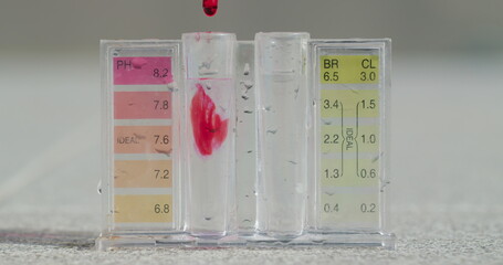 Water test for PH level. A chemical reagent is added to a test tube.