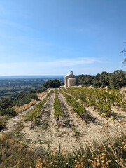 A french countryside landscape, with a vineyard and a church on a bright day on a top of a mountain