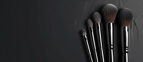Five makeup brushes of various sizes and shapes are neatly arranged on top of a counter. These brushes are essential tools for applying facial makeup and are commonly used by beauty enthusiasts and - obrazy, fototapety, plakaty