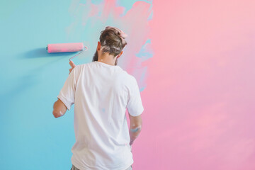 Male house painter applying pastel color with roller to a wall