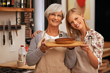 Portrait, happy woman and senior mother with pie in home, cooking or smile of family showing homemade food together in kitchen. Face, daughter and elderly mom with dessert, pastry or help with baking