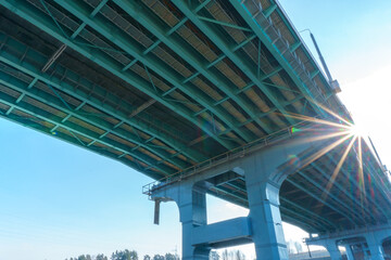 Parts of a modern metal bridge in close-up against a blue sky background. Metal structures...