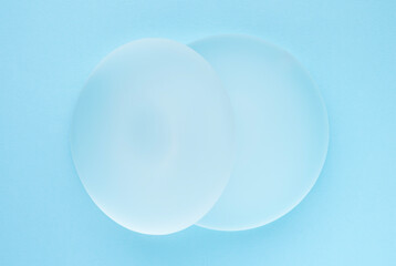Breast implants on blue background. Top view