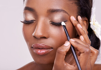 Black woman, face and brush for eyeshadow with beauty, makeup and lashes on grey background. Skin...