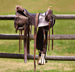 Saddle, horse and farm on ranch fence, riding and equestrian sports in country side. Western,...