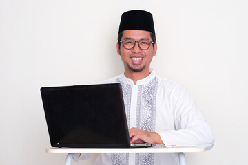 Moslem Asian man working using a laptop showing happy expression