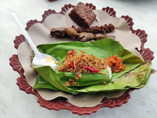 Nasi angkringan or nasi kucing. indonesian traditional food from central java. Popular snack rice dish in small portion, topped with variety of toppings and side dishes of fried food, satay, and crack