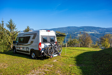 Campervan or motorhome with bicycle rack parked in the nature countryside. Camper van or  motor...
