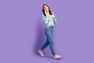 Full length photo of cheerful dreamy lady dressed cardigan talking apple samsung iphone device empty space isolated violet color background