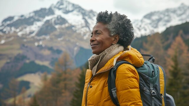 portrait of an Afroamerican woman in a yellow jacket, hiking in the mountains. Outdoor concept. Travel image style. For shop, banner, design, poster, advertisement
