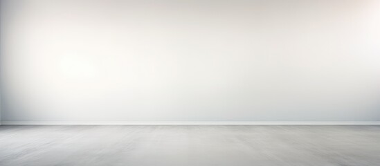 An empty room with a white wall and floor. The light grey background creates a muted ombre pattern, blending into the blurred texture of the abstract interior.