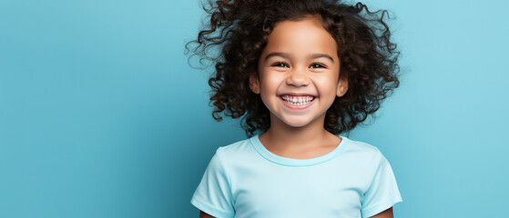 laughing child in blank t-shirt on an isolated blue solid background perfect photo for advertising, with empty copy space - obrazy, fototapety, plakaty