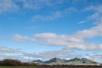 The Sutter Buttes, known as the Smallest Mountain Range, on a partly cloudy day and blue sky copy-space - 748090444