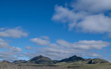 The Sutter Buttes, known as the Smallest Mountain Range, on a partly cloudy day and blue sky copy-space - 748090608