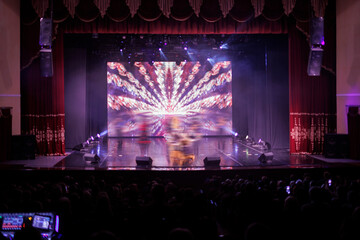 An empty stage of the theater, lit by spotlights and smoke before the performance