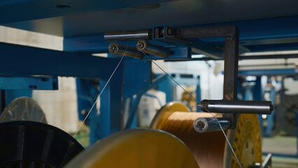 Rotating coils with wires at factory. Creative. Distribution and winding of wires on coils at...