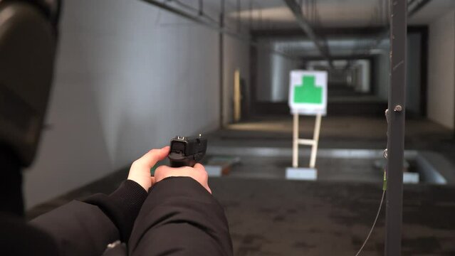 A girl fires a gun. Shooting range. Shooting from a gun. Shooting from a machine gun. Training in shooting. Guns.