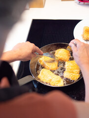 anonimous senior woman cooking fried fish