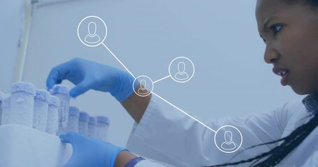 Animation of glowing light trails over biracial female scientist in laboratory - Powered by Adobe